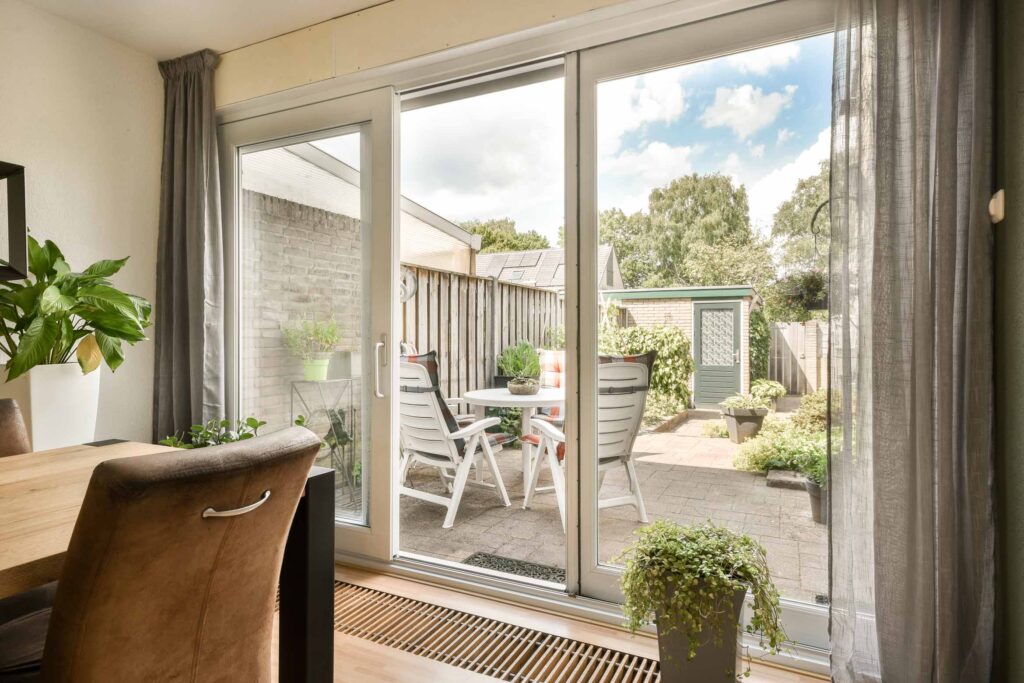 A Living Room With Large Windows And A Patio With